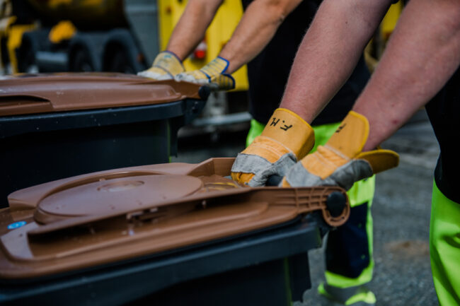 Zwei Müllwerker beim Abtransport der Biotonne