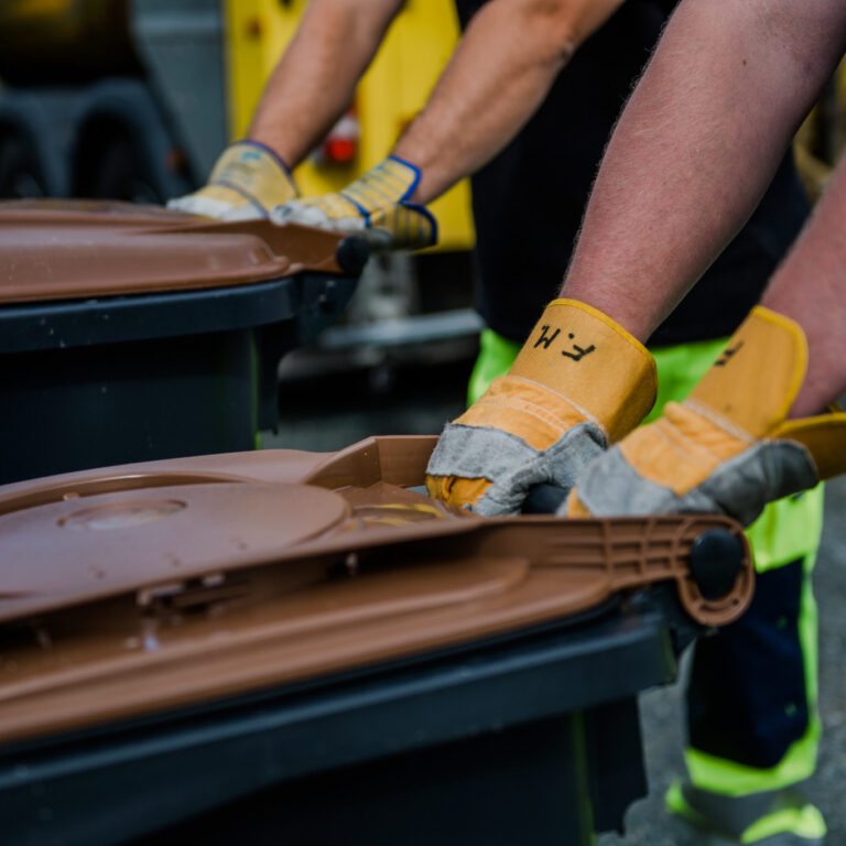 Zwei Müllwerker beim Abtransport der Biotonne