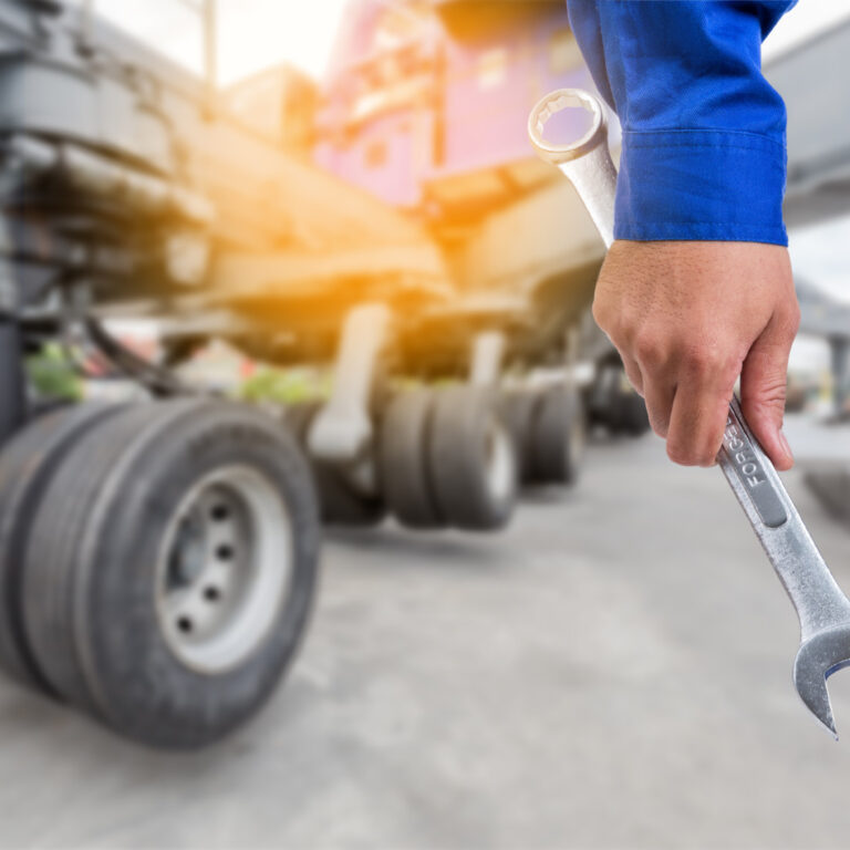 KFZ Mechatroniker mit einem Schraubenschlüssel in der Hand
